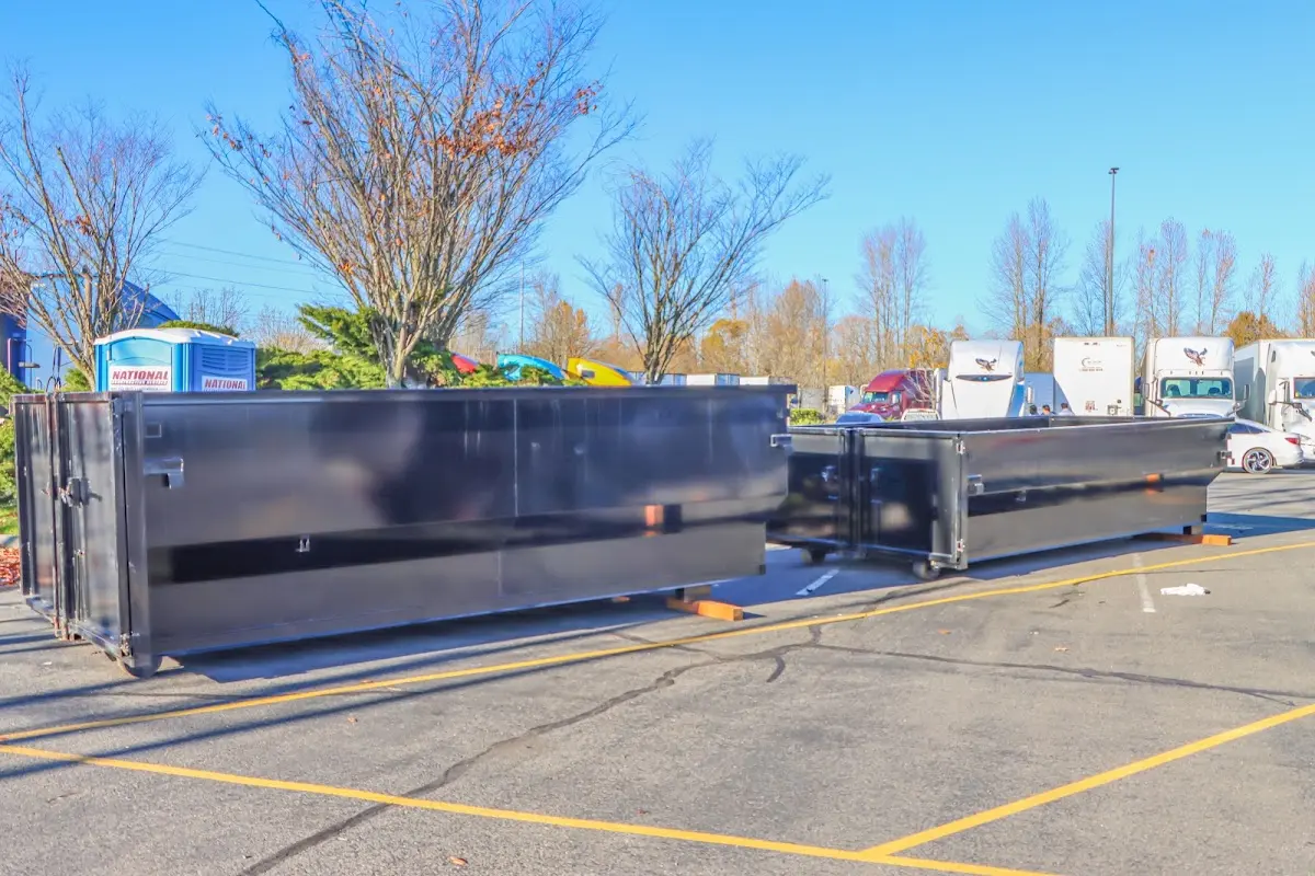 Professional dumpster rental service with roll-off container on residential driveway in Derby